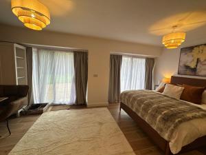 a bedroom with a bed and two large windows at Longovers Lodge in Westbourne