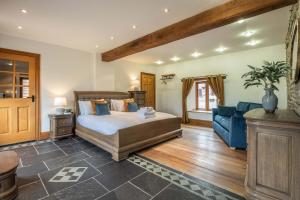 a bedroom with a bed and a blue couch at Stud Farm House in Bleddfa