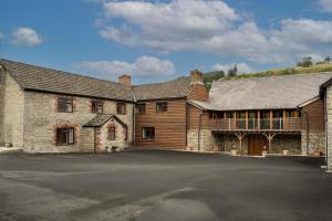 a large wooden building with a parking lot at Stud Farm House in Bleddfa