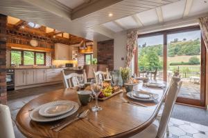 a kitchen and dining room with a wooden table at Stud Farm House in Bleddfa