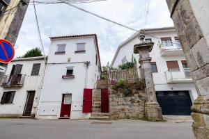 a white building with red doors on a street at Portas de Caminha I in Caminha