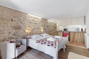 a bedroom with a bed and a stone wall at Portas de Caminha I in Caminha