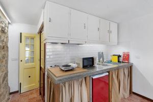 a kitchen with white cabinets and a counter top at Portas de Caminha I in Caminha +15 photos