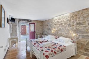 a bedroom with a bed and a stone wall at Portas de Caminha I in Caminha