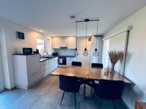 a kitchen with a wooden table and chairs at Ferienwohnung am Vechtedamm in Hoogstede