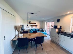 a kitchen and dining room with a table and a blue couch at Ferienwohnung am Vechtedamm in Hoogstede +6 photos