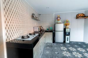 a kitchen with a black counter and a refrigerator at Komala Indah 2 in Badung