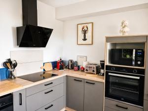 a kitchen with a counter top with a microwave at La Maison des Falaises in Crozon