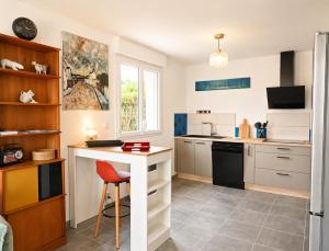 a kitchen with a counter and a table with a chair at La Maison des Falaises in Crozon