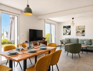 a living room with a wooden table and chairs at La Maison des Falaises in Crozon +28 photos