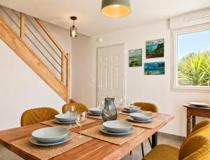 a dining room with a wooden table and chairs at La Maison des Falaises in Crozon