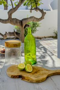 a green bottle and two lime slices on a cutting board at Zen Milos Green Apple in Pollonia