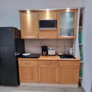 a small kitchen with wooden cabinets and a black refrigerator at Favola Marina in Scalea +3 photos