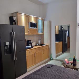 a kitchen with wooden cabinets and a black refrigerator at Favola Marina in Scalea
