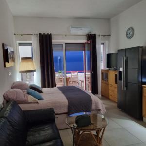 a bedroom with a bed and a couch and a television at Favola Marina in Scalea