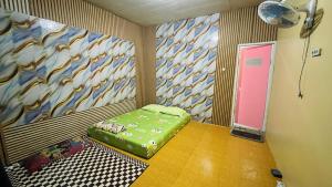 a room with a green ottoman and a pink door at Bintang Sawarna 2 By ARBA in Sawarna