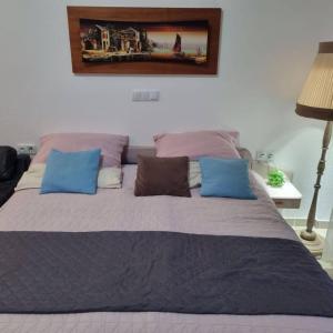 a bed with blue and pink pillows in a bedroom at Favola Marina in Scalea