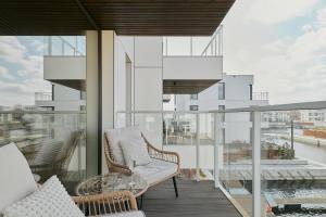 a balcony with a couch and a chair on a building at Sol Marina Riverview with free Parking & SPA additional by Downtown Apartments in Wiślinka +50 photos