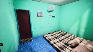 a small room with a bed with blue walls at Bintang Sawarna 2 By ARBA in Sawarna +2 photos