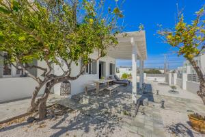 a patio with trees in front of a house at Zen Milos Green Apple in Pollonia