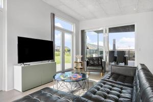 a living room with a couch and a flat screen tv at 30441-Odder-Strandvaenget-12 in Odder