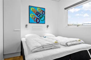 a white bed in a room with a painting on the wall at 30441-Odder-Strandvaenget-12 in Odder