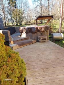 a wooden deck with a hot tub and a bench at Pori-Kõrtsi talu in Nasja +2 photos