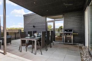 a patio with a table and chairs and a stove at 30441-Odder-Strandvaenget-12 in Odder