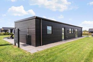 a black tiny house in a yard at 30441-Odder-Strandvaenget-12 in Odder