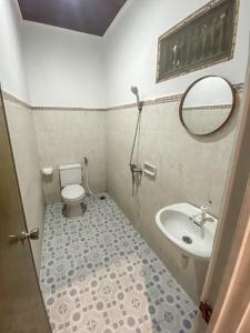 a bathroom with a sink and a toilet and a mirror at Komala Indah 2 in Badung