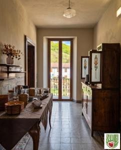 a dining room with a table and a large window at Ca' Giulia in Rigoso