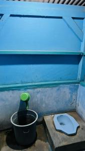 a blue bathroom with a toilet and a bucket at Bintang Sawarna 2 By ARBA in Sawarna