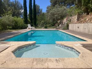 a swimming pool with a chair in a yard at Villa de la Baume in Gémenos