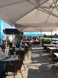 a group of people sitting at tables under an umbrella at Safari Lodge Grou, luxe kamperen op een eiland! in Grou