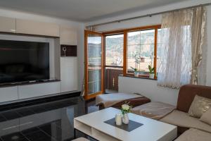 a living room with a couch and a tv at Ferienwohnungen Tarmann in Bodensdorf