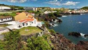 a house on a hill next to the water at Cliff House, Azores splendid Ocean View in Horta