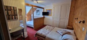 a small bedroom with a bed and a tv at Hôtel du Centre in Villard-de-Lans