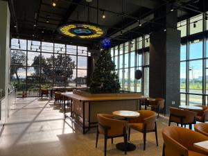 a restaurant with a christmas tree and tables and chairs at The First Clark Hotel and Residence in Pampang