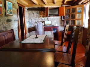 a dining room with a wooden table and chairs at Río da Cruz in Cariño