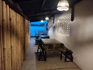 a room with a table and some chairs and a light at YANTO BEACH HAUS at CAGWAIT WHITE BEACH in Cagwait