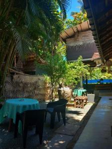 a patio with a blue table and chairs and trees at Avalon Villa Unawatuna in Unawatuna