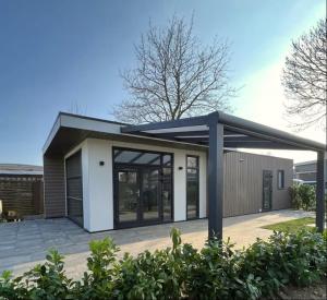 a small house with a blue roof at Rhederlaagse Meren in Lathum