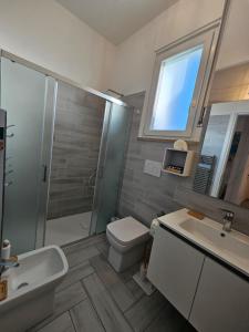a bathroom with a toilet and a sink and a shower at Galactic Sea in Comacchio +92 photos