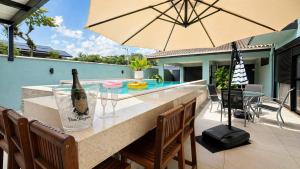 a bar with a bottle of wine and an umbrella at Casa Premium no Centro - Passos do Alles Park in Pomerode