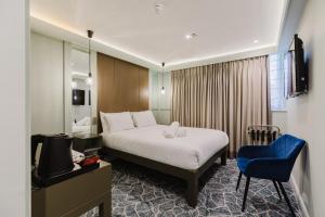 a hotel room with a bed and a blue chair at The Lancaster Hotel in London