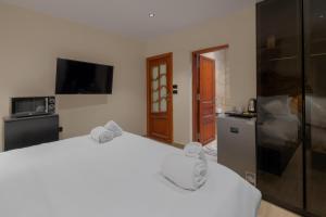 a bedroom with two beds and a tv and a refrigerator at M-Residence By Brassbell in Cairo