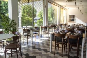 a restaurant with tables and chairs and large windows at Hotel Del Conte in Fondi