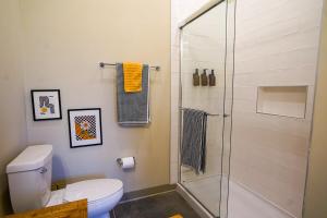 a bathroom with a toilet and a glass shower at Ruby Suite - New 2 bdrm 2bath near Mass! in Lawrence +19 photos
