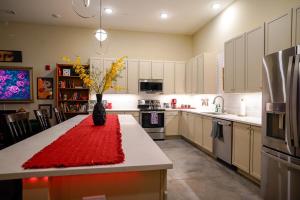 a kitchen with a table with a vase of flowers on it at Ruby Suite - New 2 bdrm 2bath near Mass! in Lawrence