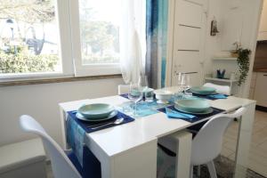 a dining room with a white table and chairs at Galactic Sea in Comacchio